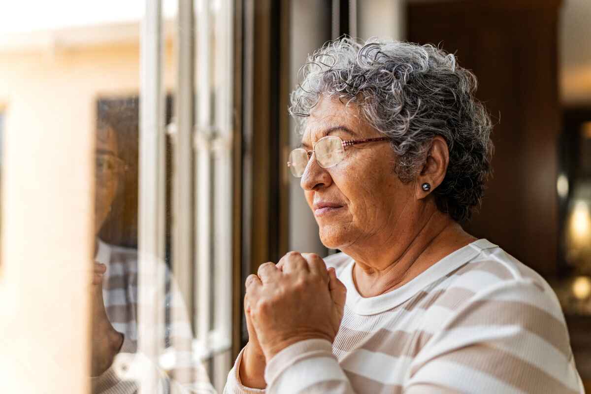Elderly woman looks out the window